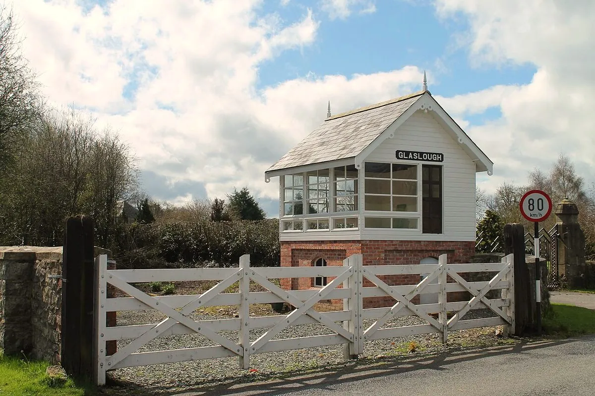 Old railway signal box by a white gate in Glaslough